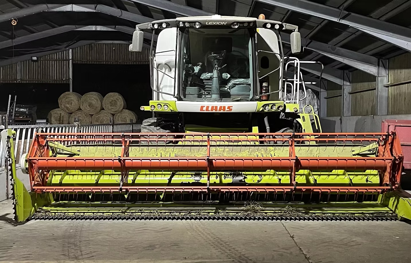 CLAAS Lexion combine with header parked in a barn