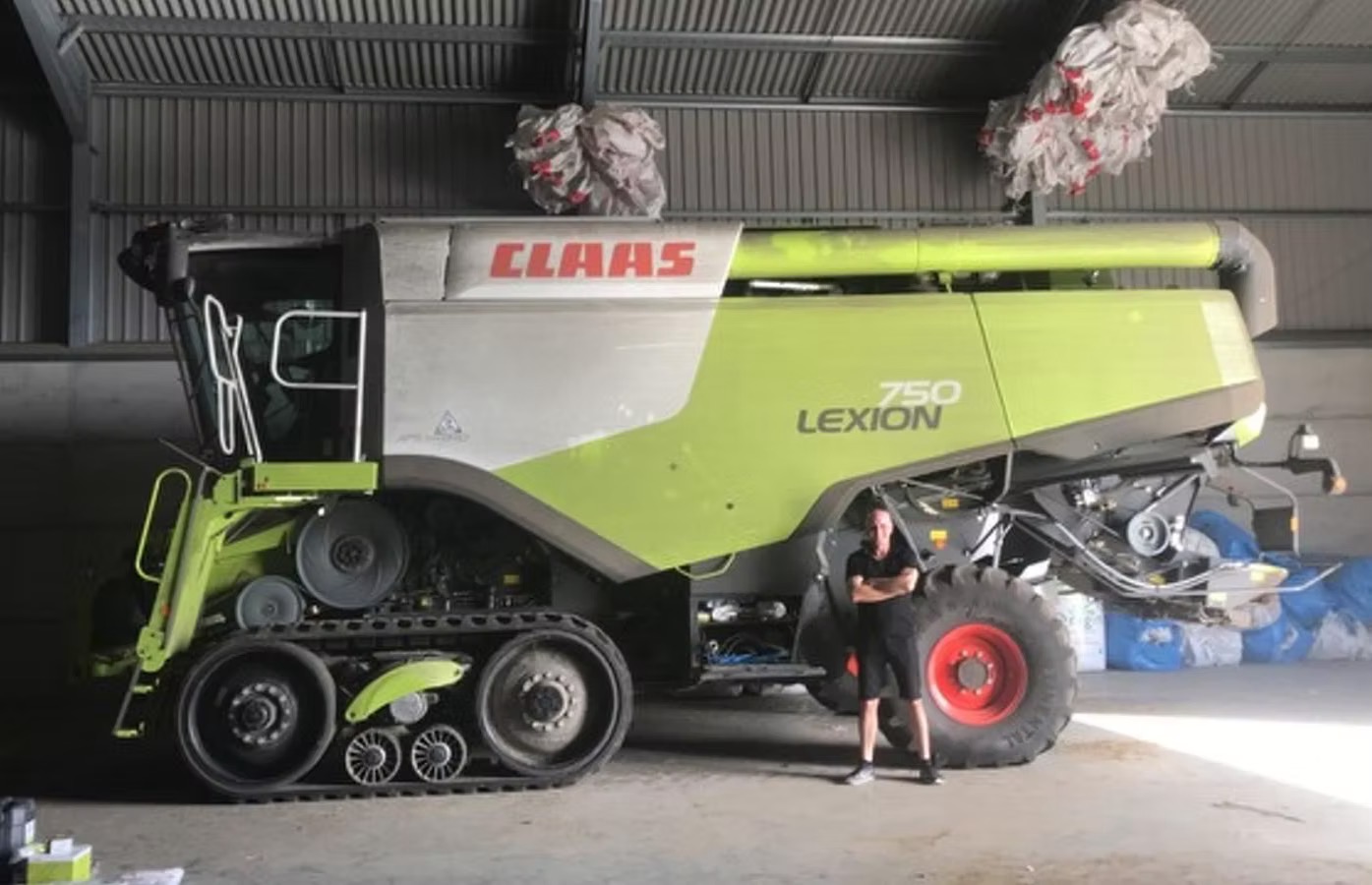 CLAAS Lexion 750 on tracks parked inside a shed